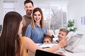 Parents and kids at dental reception desk