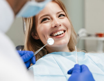 Smiling woman receiving treatment from dentist in Buzzards Bay