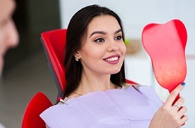 Woman looking at her smile in mirror