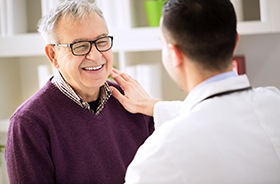 Smiling patient and dentist discussing how to pay for dental implants in Buzzards Bay