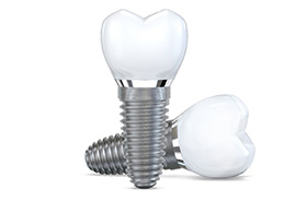 Two dental implants and crowns arranged against white background