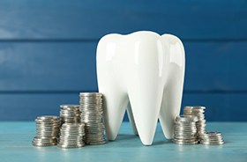 Tooth model surrounded by stacks of coins