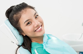 Smiling female dental patient in treatment chair