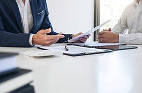 Two men conversing over paperwork