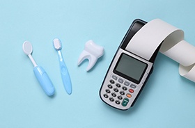 Calculator next to dental care tools