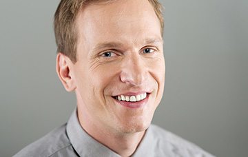 Man with light brown hair smiling