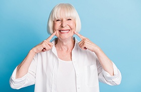 Senior woman showing off her fixed implant denture