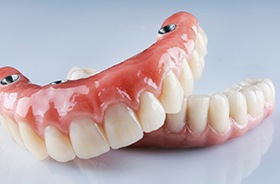 Set of implant dentures against neutral background