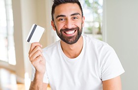 Happy, smiling man holding payment card