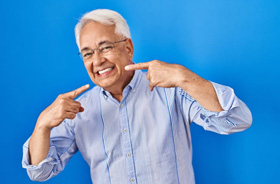 Happy senior man pointing at his smile