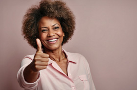 Mature woman making thumbs-up gesture