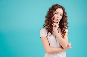 Woman thinking, considering root canal vs. tooth extraction cost