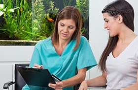 Woman using card to pay for her dental treatment