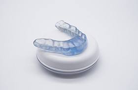 Occlusal splint sitting on top of its storage case