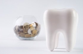 Tooth model in foreground, jar of change in background