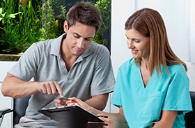 Male patient using card to pay for treatment