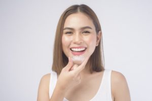 Happy young woman in process of fixing TMJ with Invisalign