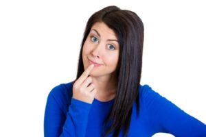 Woman in blue shirt with curious expression on her face