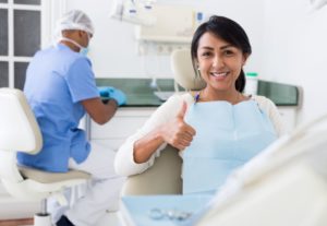Happy female dental patient making thumbs up gesture