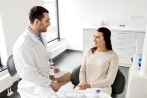 Dentist and patient talking during dental implant consultation 